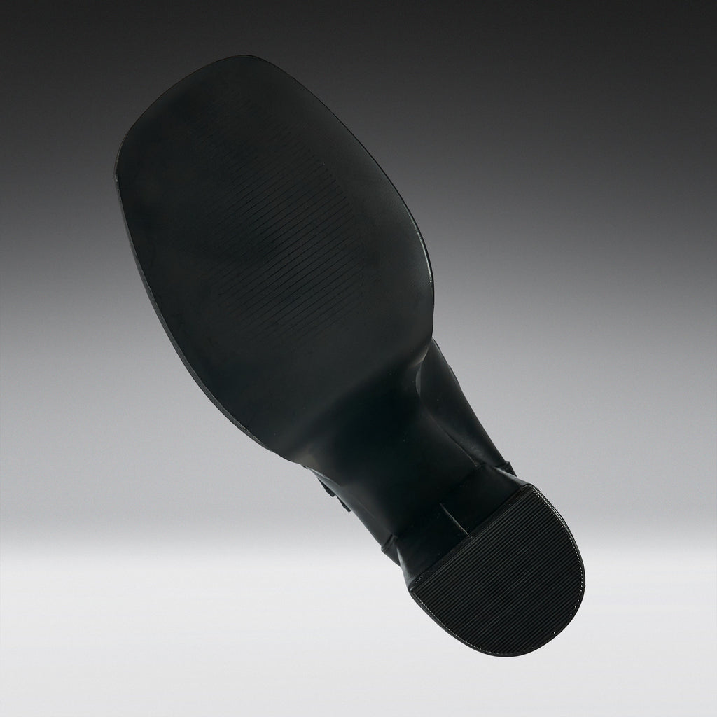 A black shoe sole shown floating against a gradient gray background.