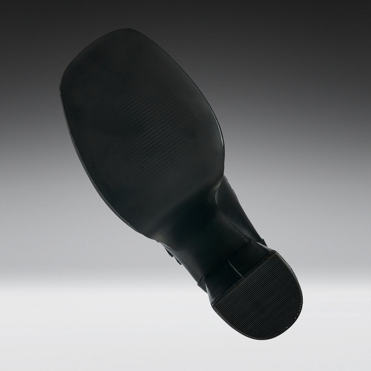 A black shoe sole shown floating against a gradient gray background.