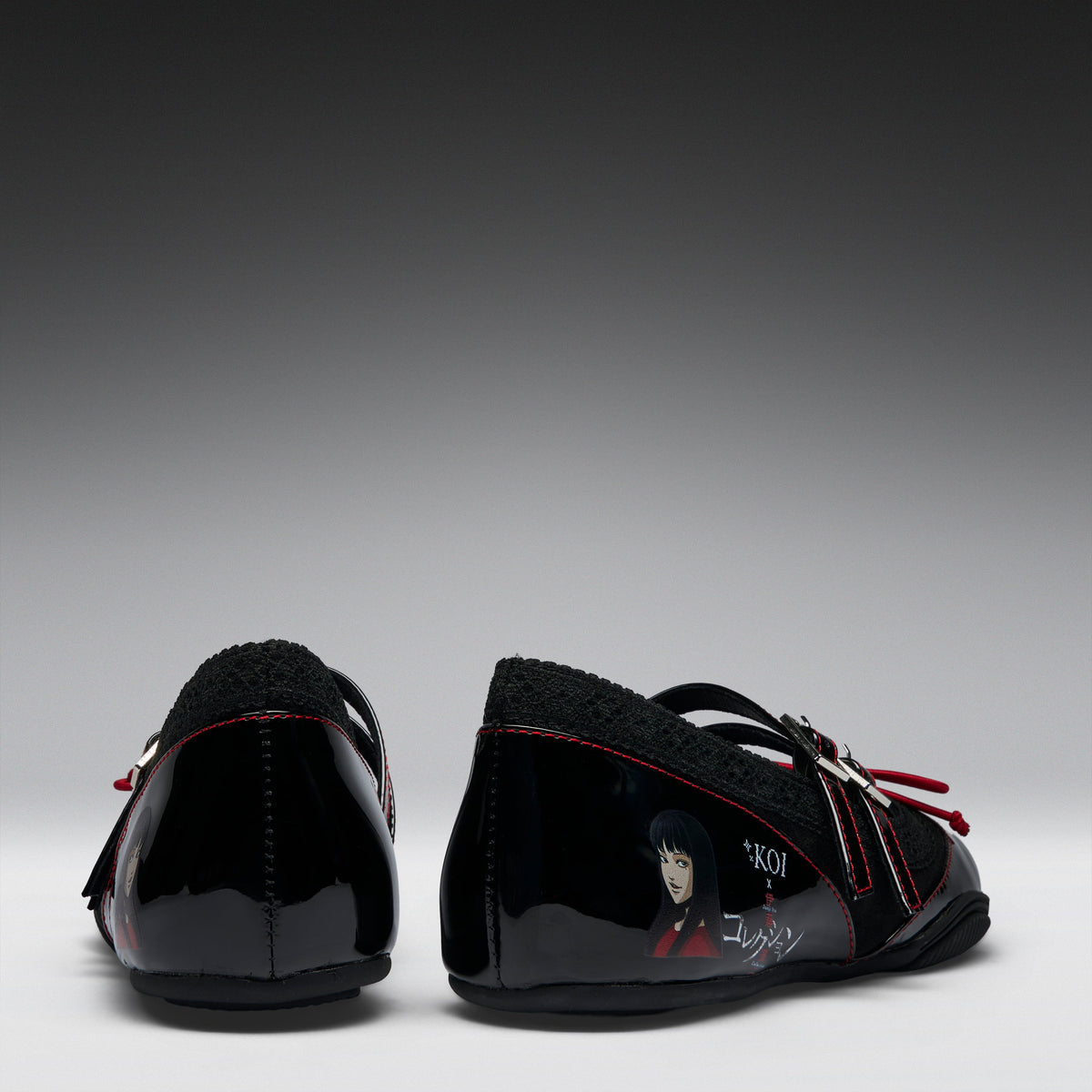 A pair of black patent leather Mary Jane shoes with black fleece lining, red contrast stitching, and character graphics on the sides, shown from the back against a gradient gray background.
