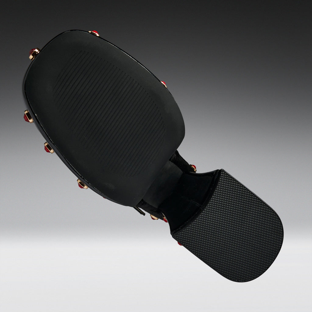 Black martial arts kicking pad with a textured head and a padded striking surface, shown floating against a dark gray gradient background.