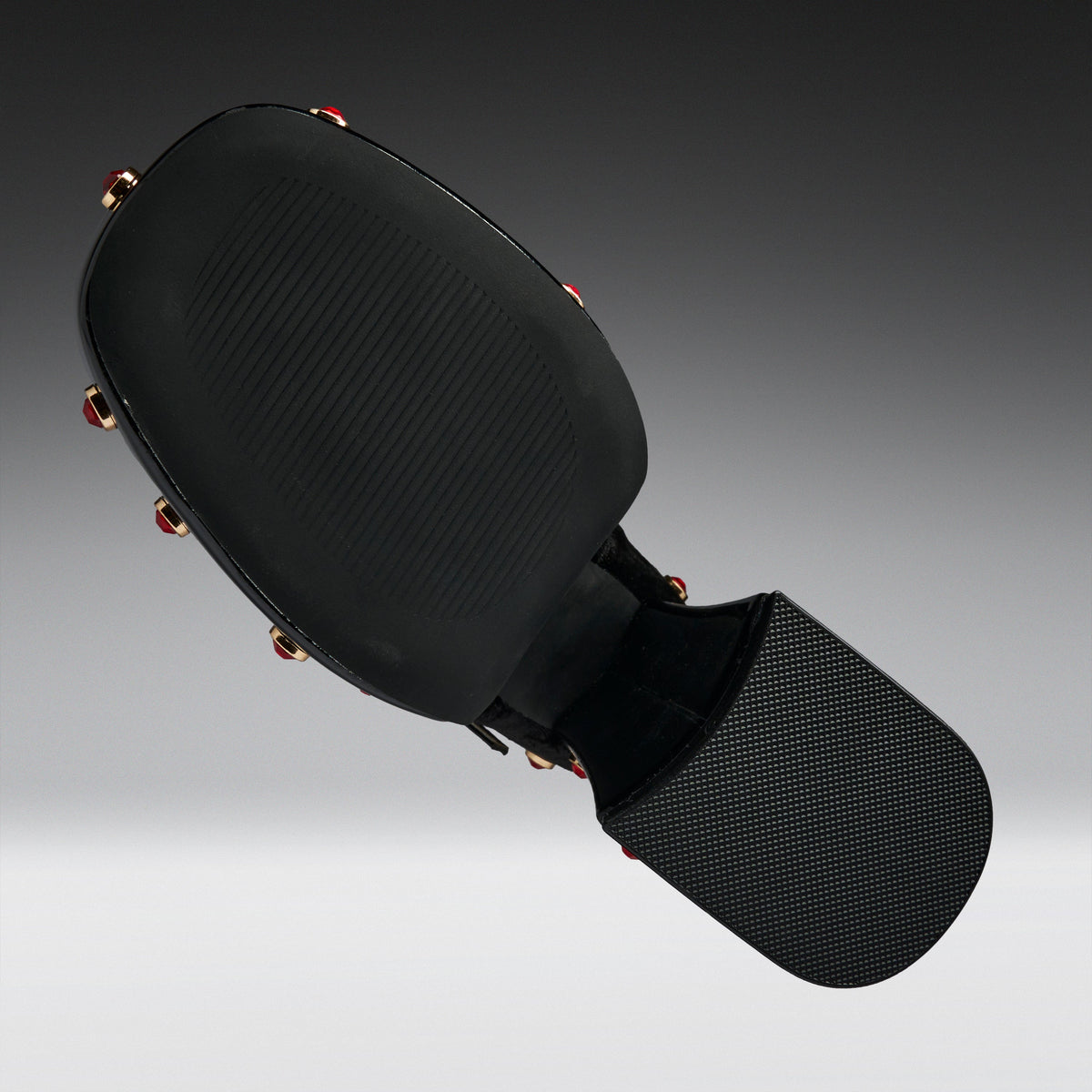 Black martial arts kicking pad with a textured head and a padded striking surface, shown floating against a dark gray gradient background.