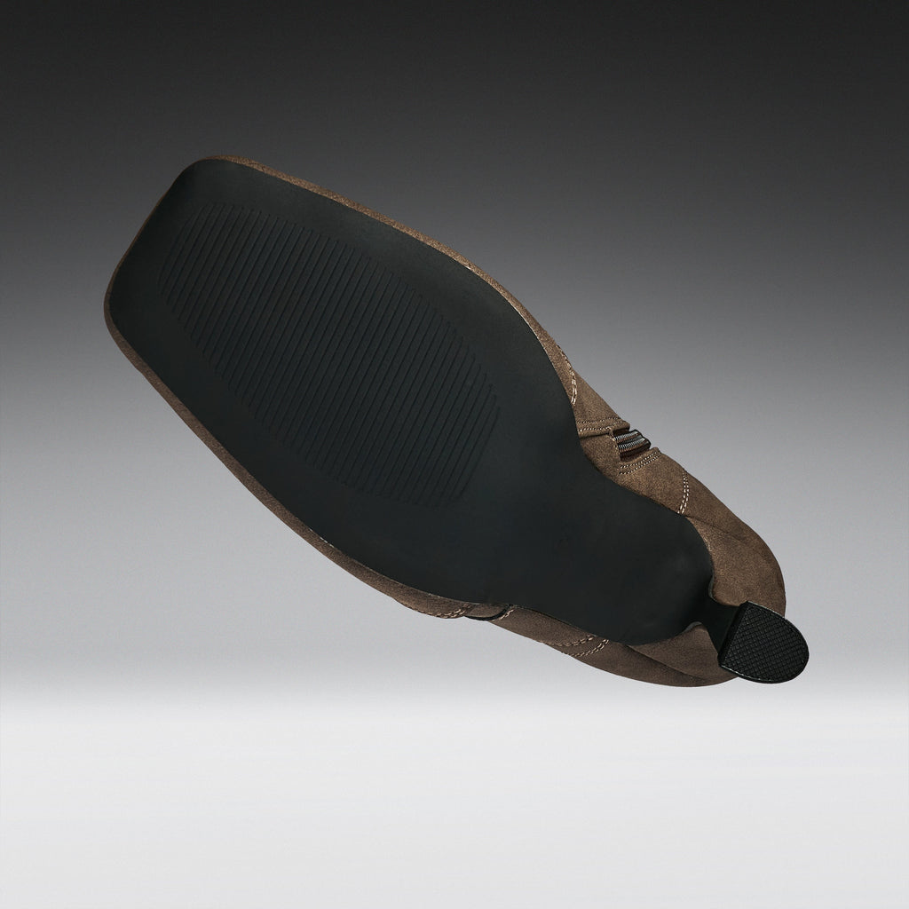 A motorcycle or bicycle leather saddle with a black textured rubber seat pad and a brown leather body, shown floating against a gradient gray background.