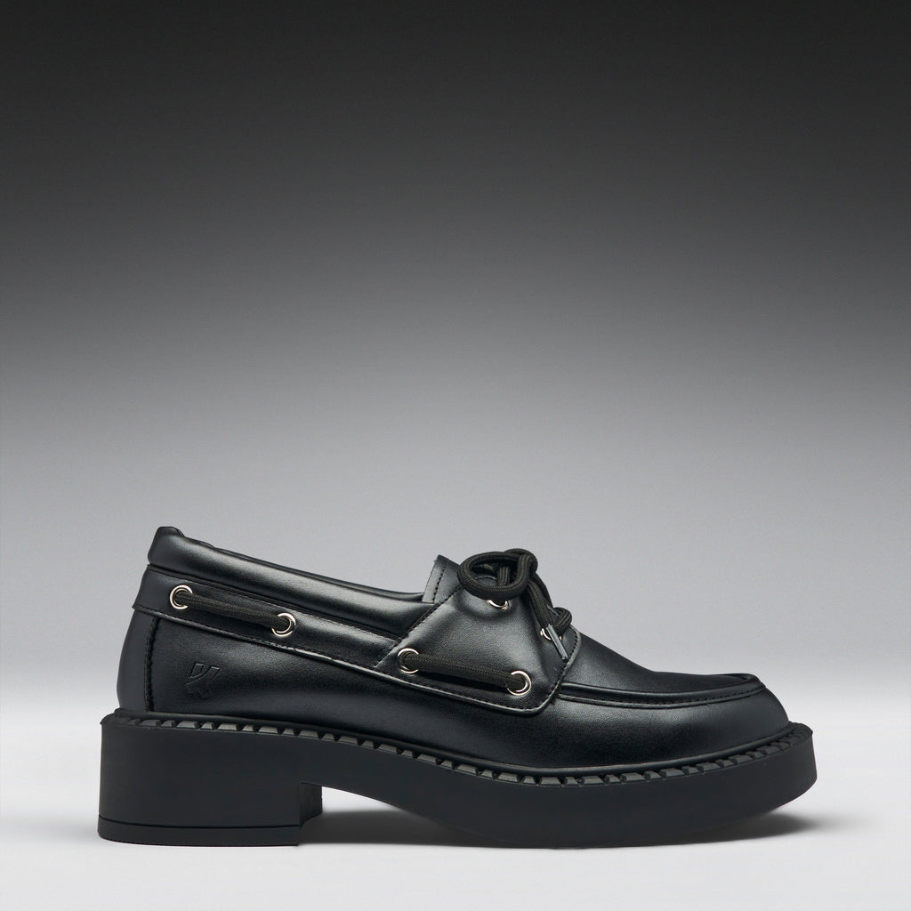 Black leather boat shoe on a gradient gray background