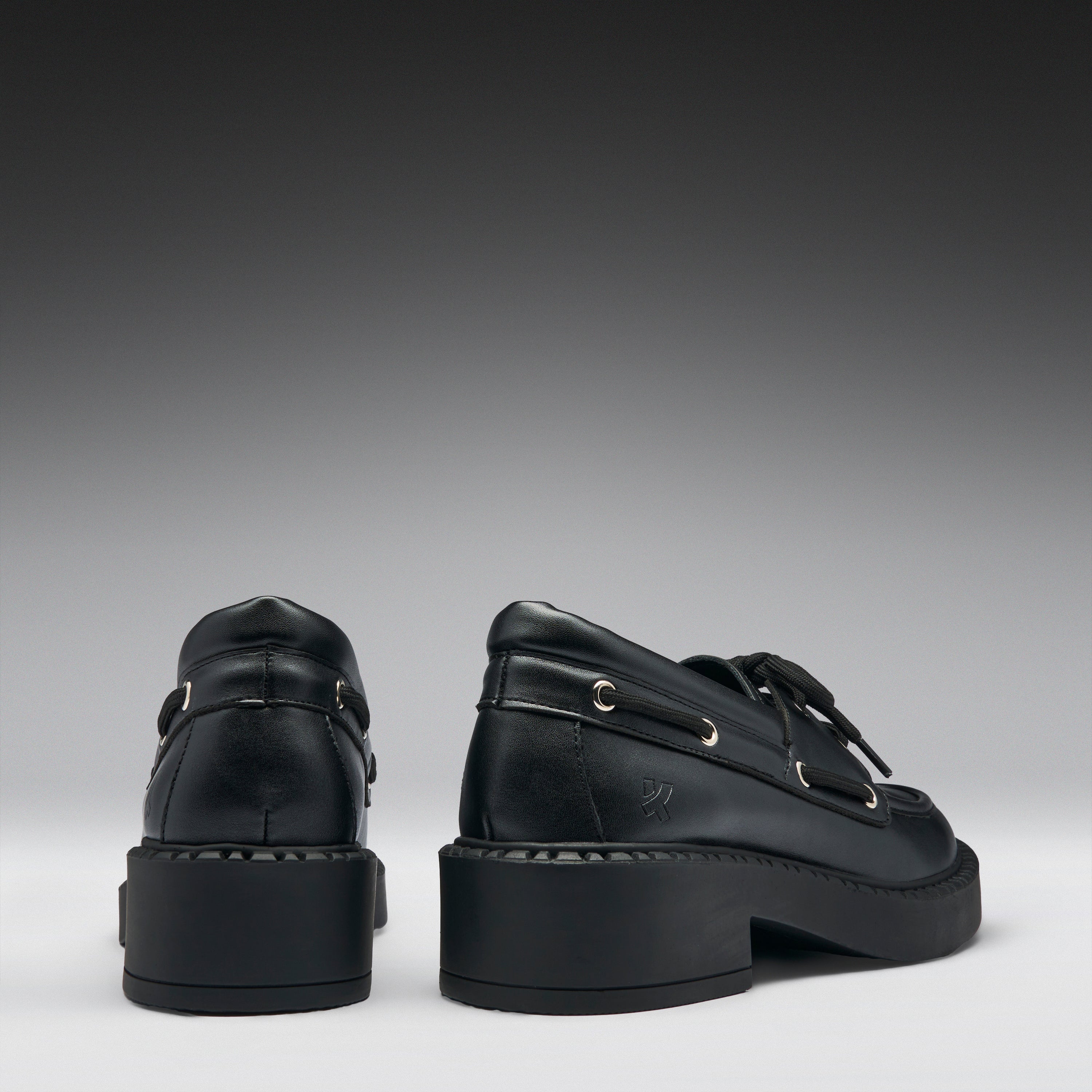 Pair of black leather shoes on a gray background