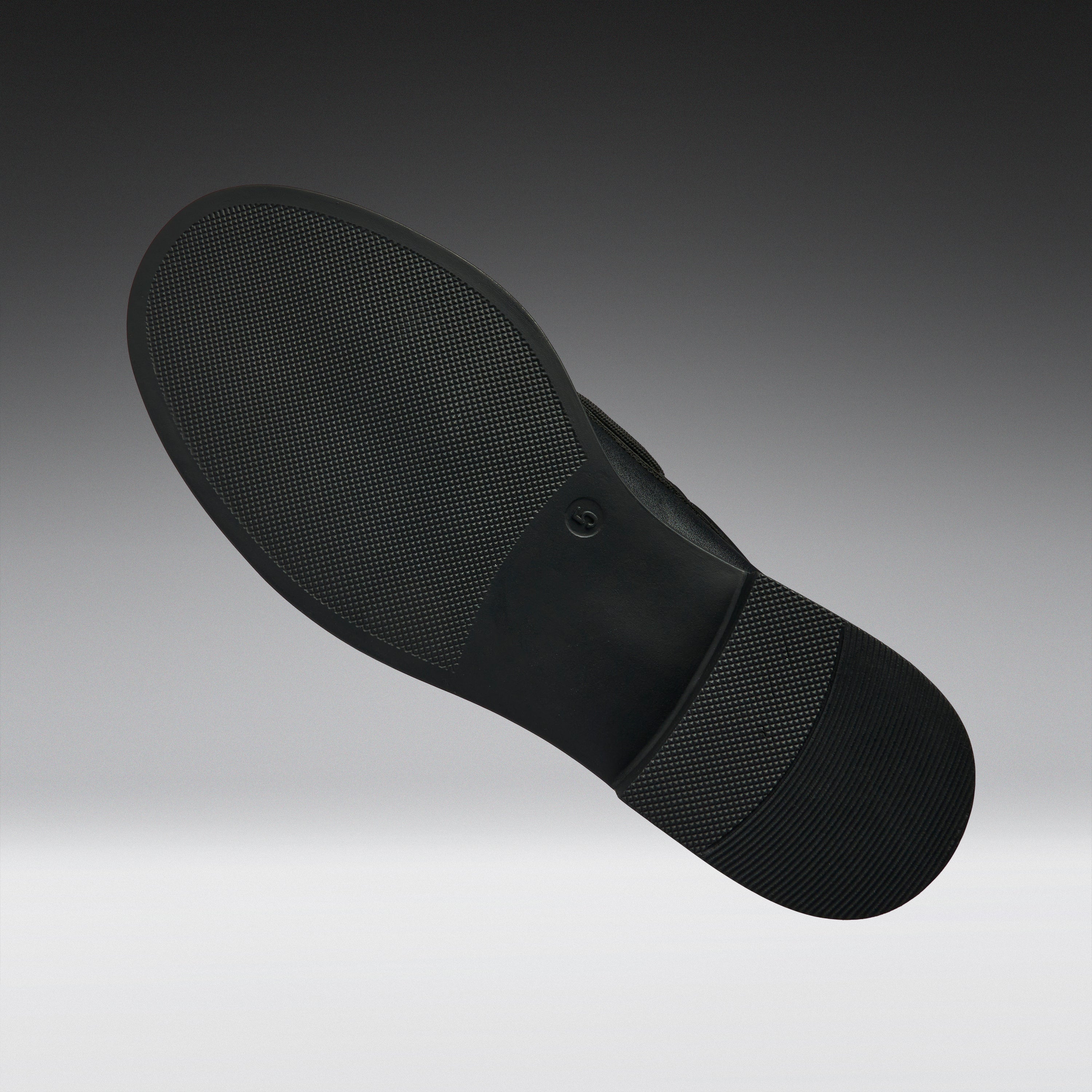 Black shoe sole on a gradient gray background
