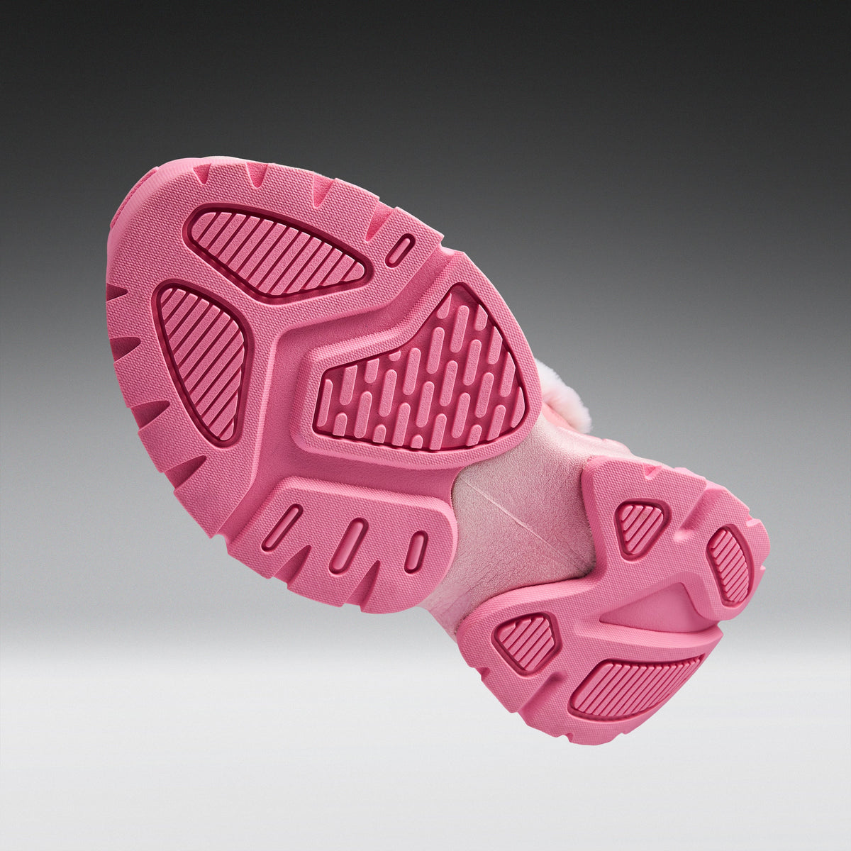 A close-up of a pink shoe sole, showing the textured tread pattern and cushioned midsole, set against a dark-to-light gray gradient background.