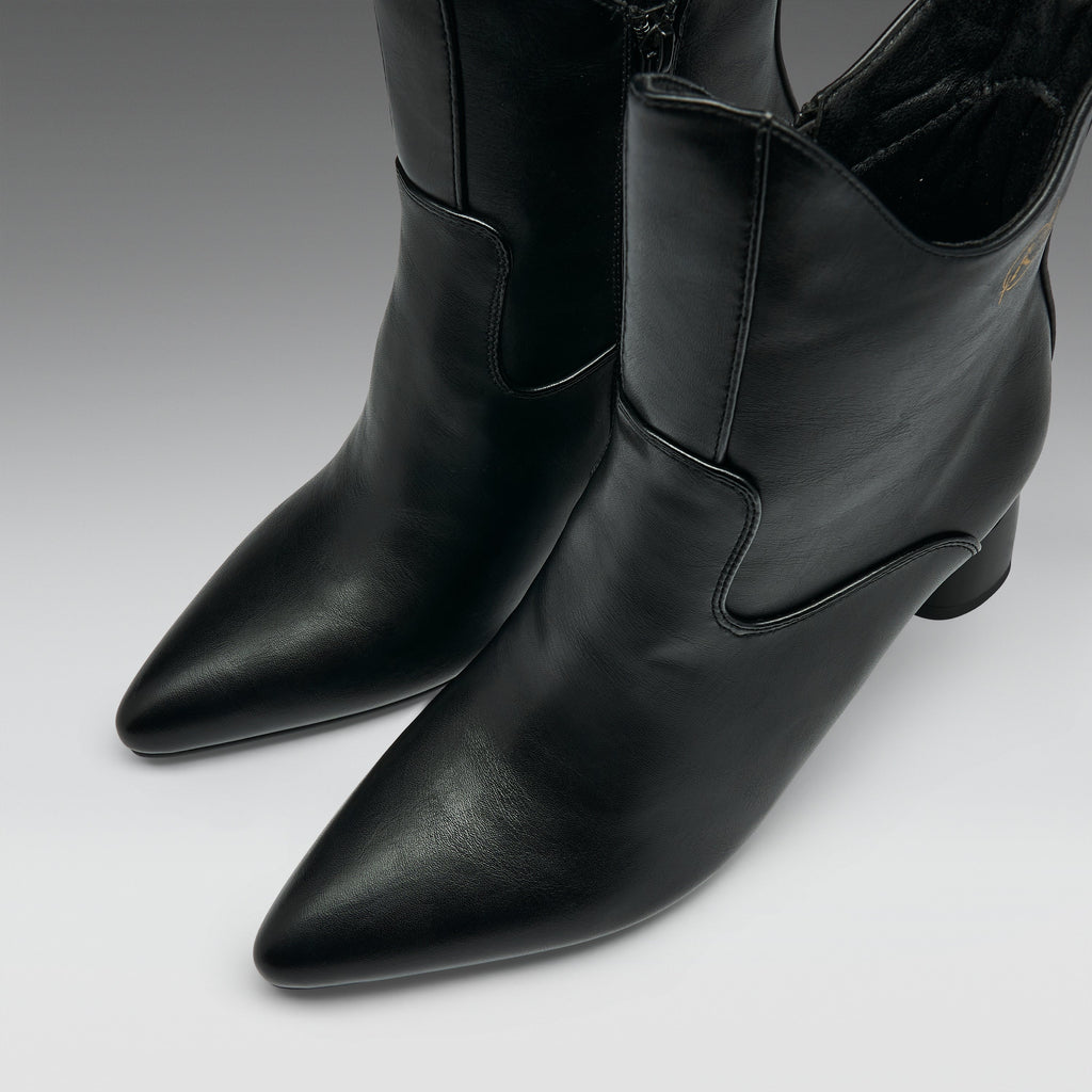 A pair of black leather pointed-toe ankle boots with a low block heel and side stitching details, photographed on a neutral gray studio background.